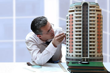 an architect studying a 3d architectural model